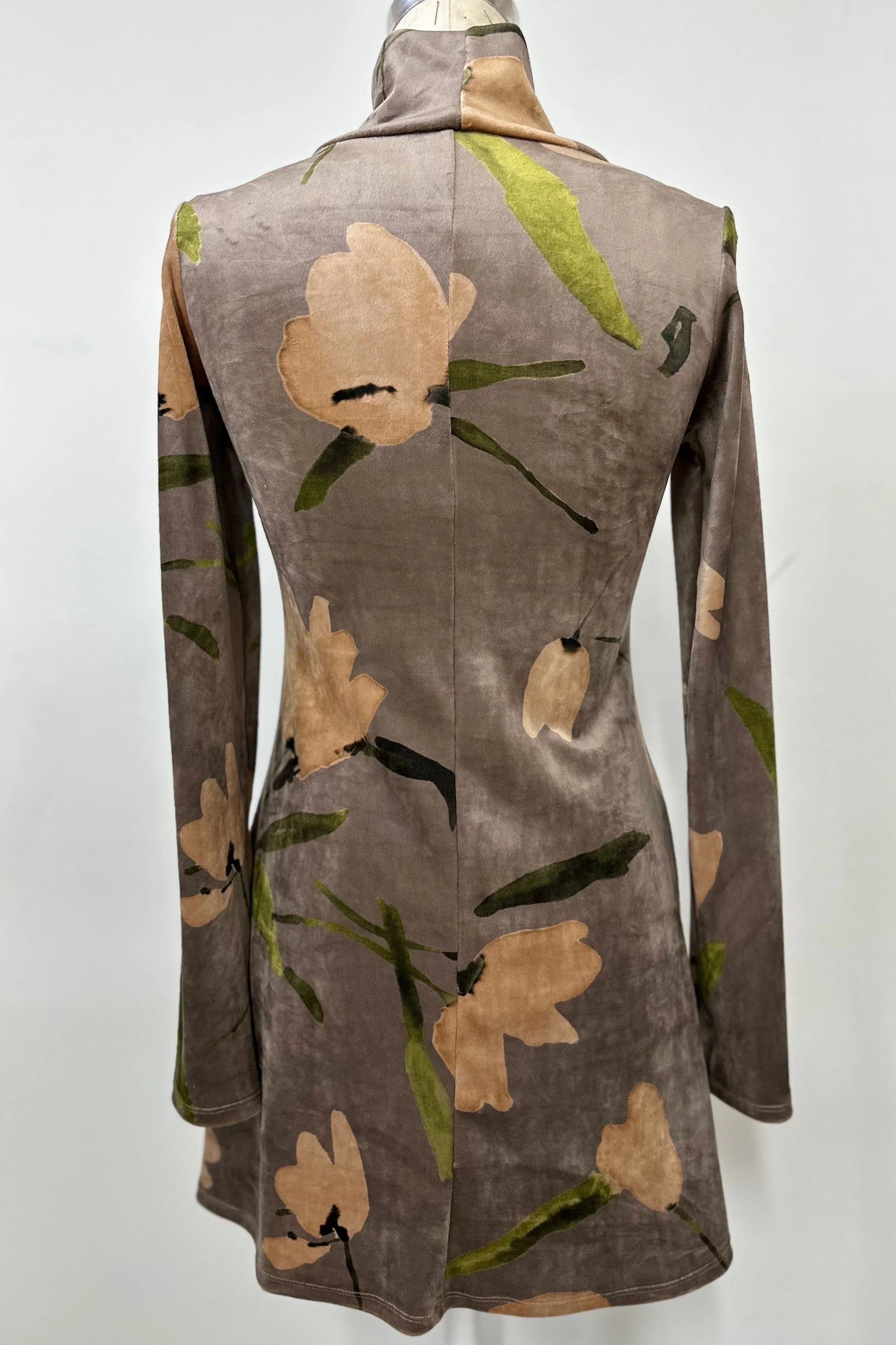 A back view of the Holly Tunic by Kollontai in Taupe, an Italian velvet A-line tunic with a turtleneck, long sleeves, and a floral print, is shown on a mannequin against a  a grey background. 