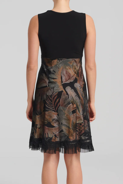 Levana Dress by Kollontai, back view, black top with wrap-over neckline and lace trim, sleeveless, empire waist, A-line skirt with tropical print under a black mesh layer, ruffled hem, knee length, sizes XS to XXL, made in Quebec