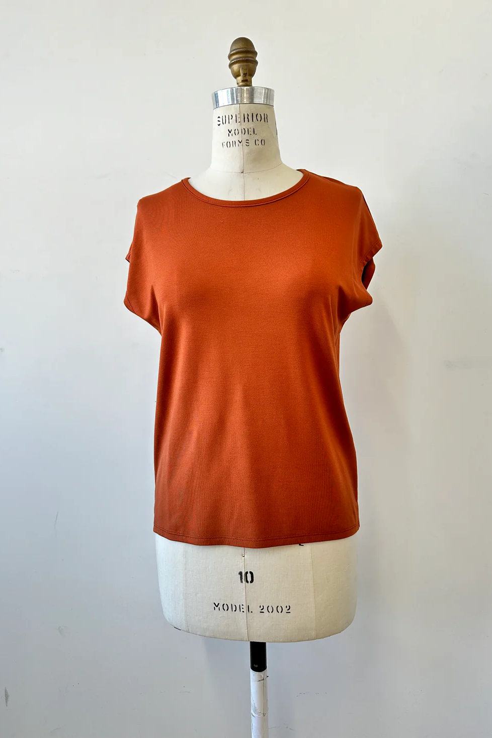 The Eowyn T-Shirt by Kollontai in Rust is shown on white mannequin against a white background 