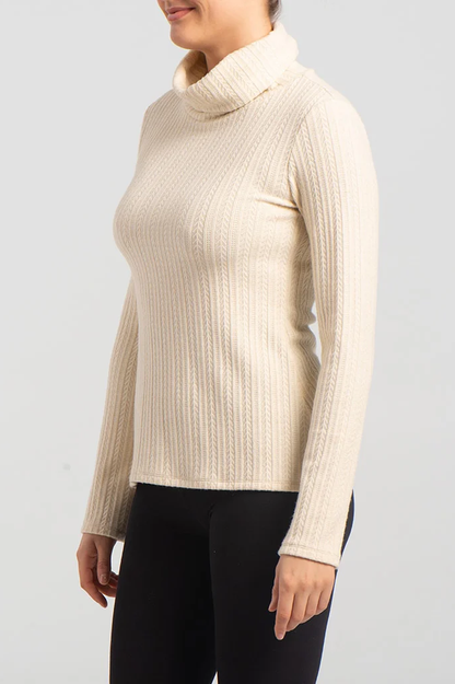 Side view close up of a woman wearing the Garfunkel Sweater by Kollontai in Cream with black pants, standing in front of a white background 