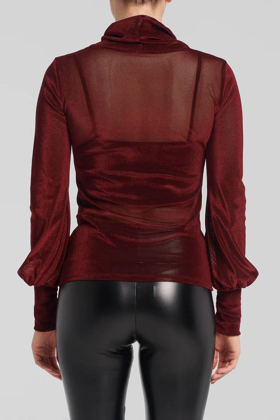 Back view of a woman wearing the Lavenza Top by Kollontai in Bordeaux with faux leather pants