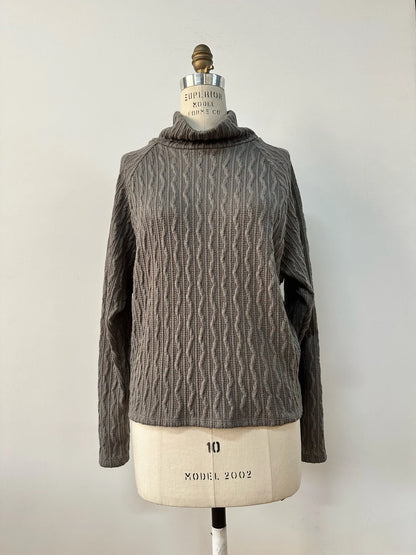 The Marianne Sweater by Kollontai in Gray is shown on a mannequin in front of a white background 