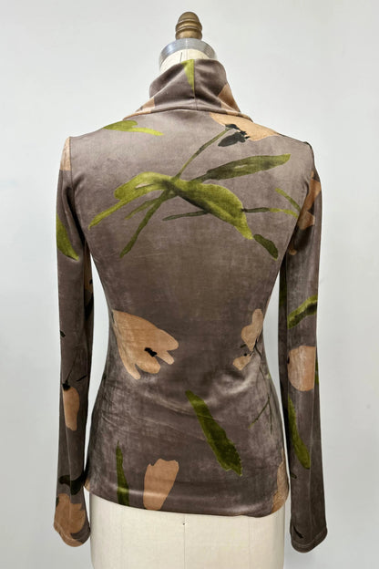 A back view of the Everdeen Turtleneck by Kollontai in Taupe, a velvet top with a floral print, is shown on a mannequin in front of a white background. 