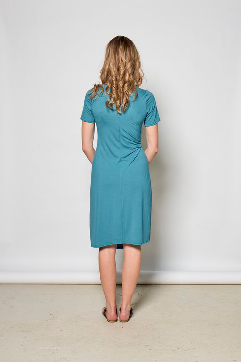 Rachelle Dress by Tangente, Fiji, back view, short sleeves, asymmetrical front hem, diagonal front seam, draping built-in ties, knee-length, anti-pill jersey, sizes XS to XXL, made in Ottawa