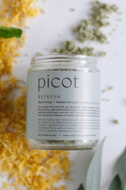 Jar of Picot salt scrub with natural elements on a light background