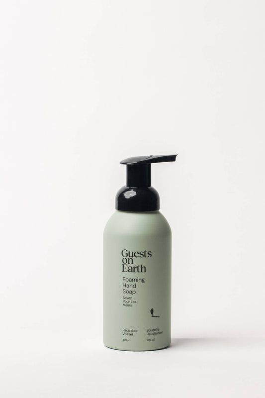 A bottle of Guests on Earth Foaming hand soap in Woodlands scent, shown against a white background 