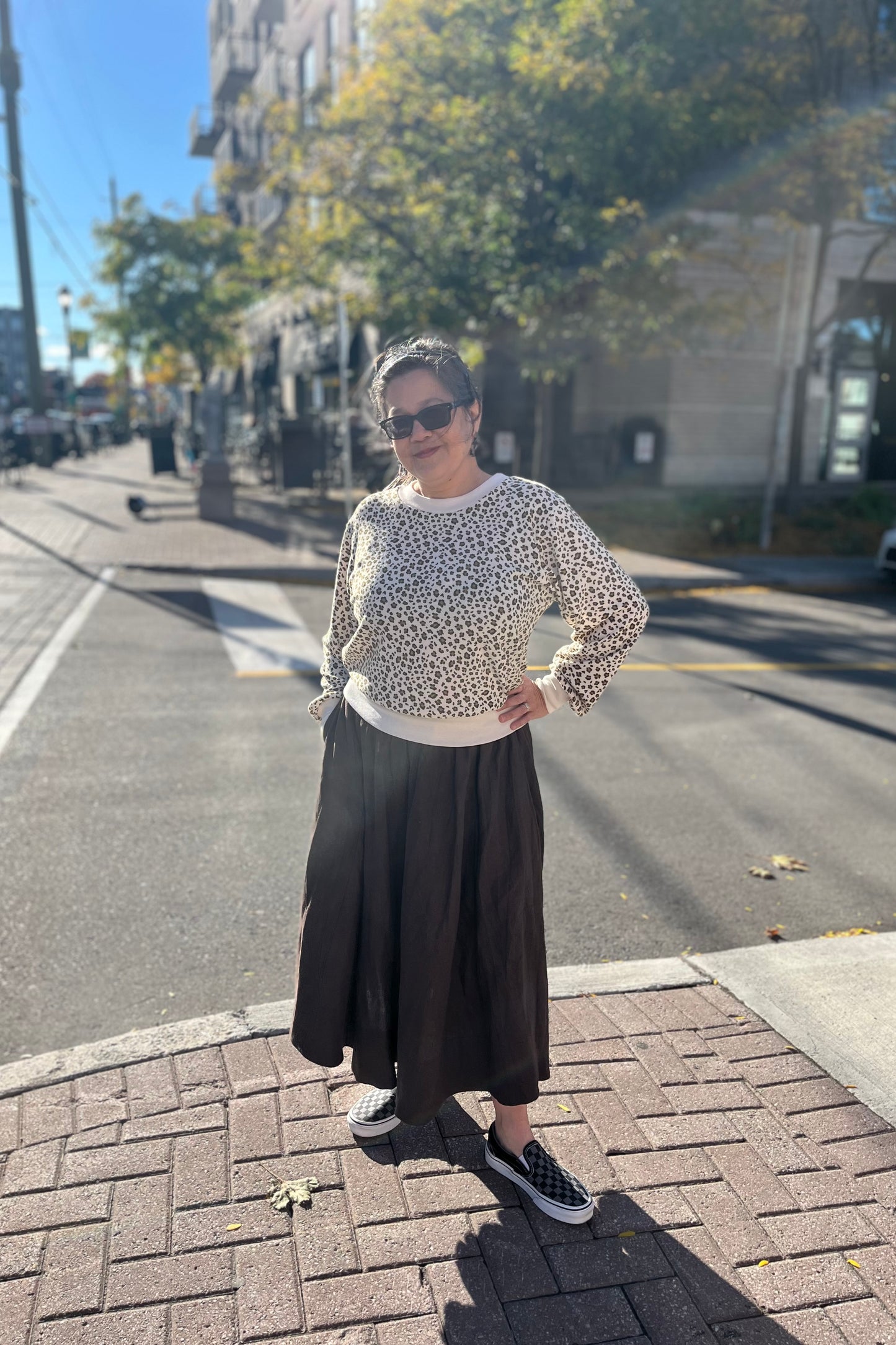 Woman wearing the Tuesday Skirt by Lights of All in Cocoa with the Wanda Sweater by Slak in Leopard and Cream