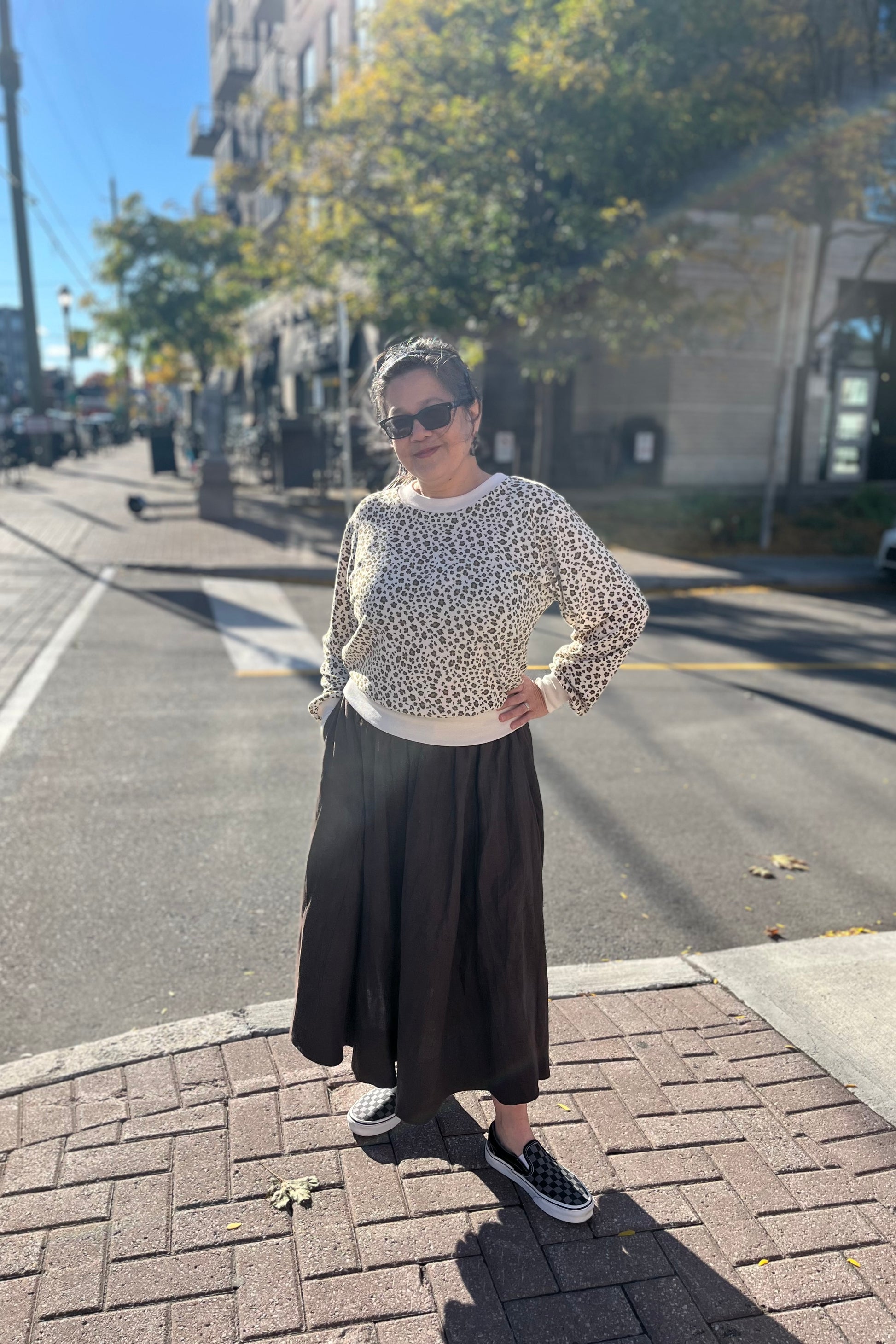 Woman wearing the Tuesday Skirt by Lights of All in Cocoa with the Wanda Sweater by Slak in Leopard and Cream