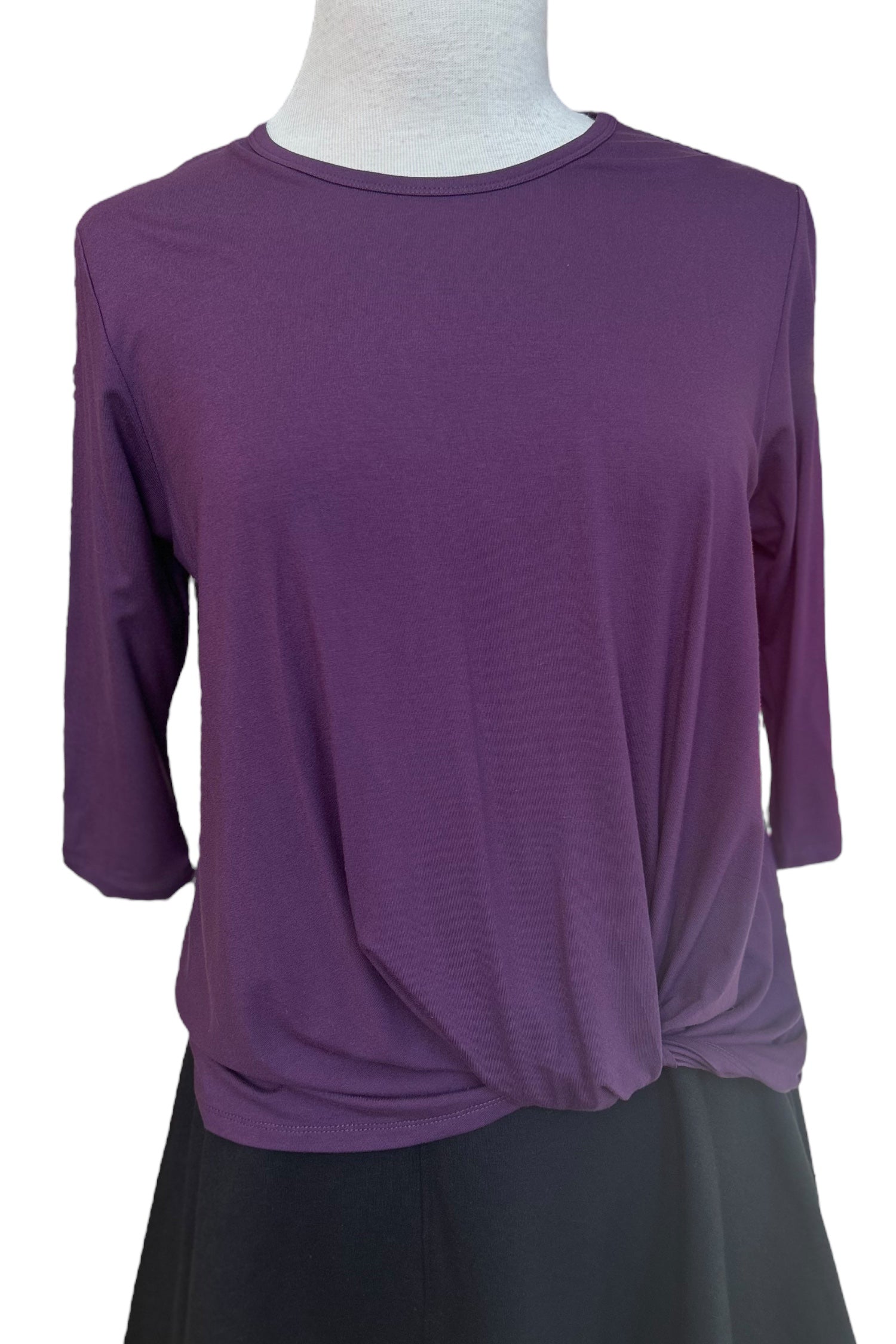 The Reese Top by Tangente in Purple, with a round neck, 3/4 drop sleeves, and a twisted hem in front, is shown on a mannequin in front of a white background. 