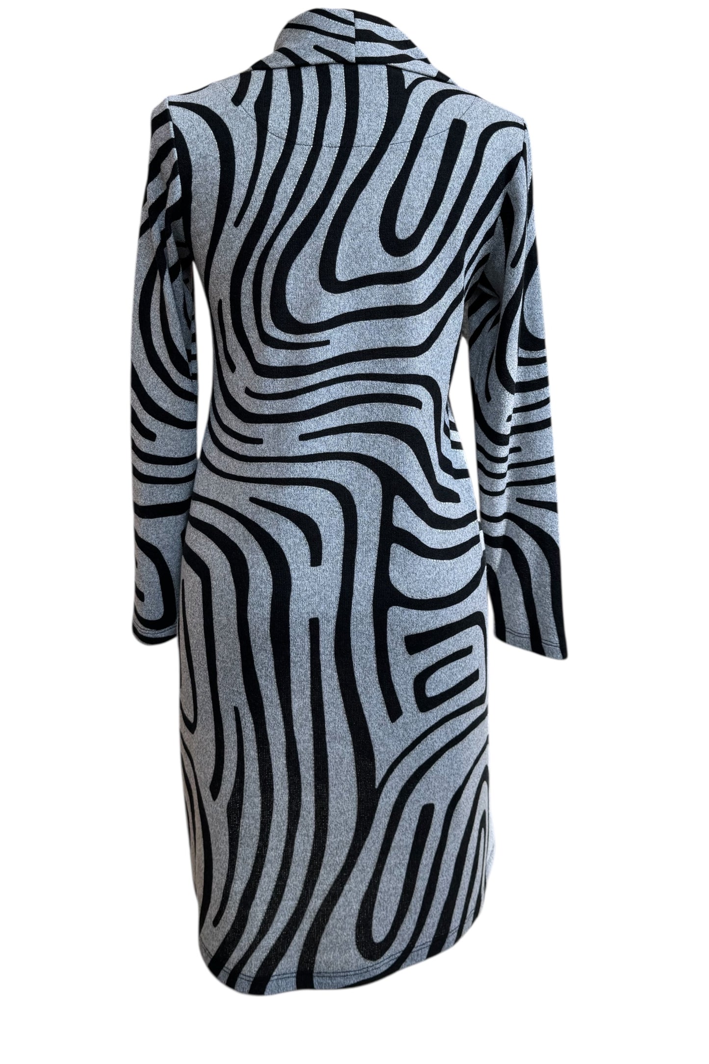 A back view of the Powell Dress by Compli K in Black and Silver Swirl, featuring a cowl neck, long sleeves, and a slight trapeze shape, is shown in front of a white background. 