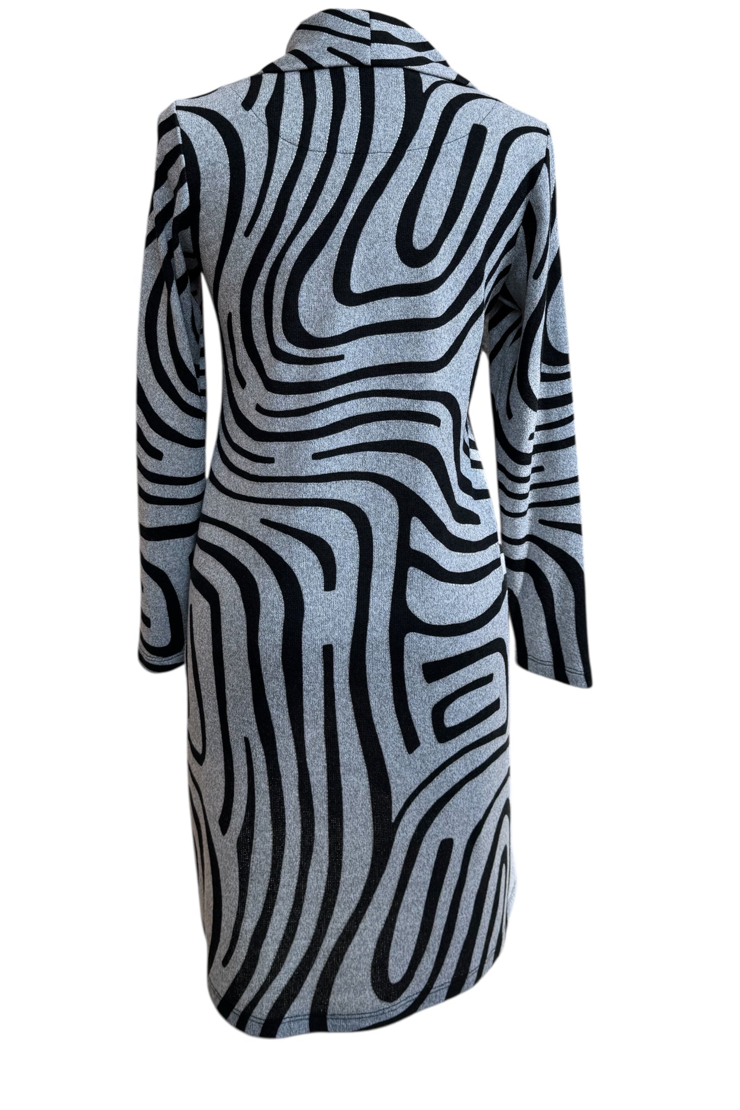 A back view of the Powell Dress by Compli K in Black and Silver Swirl, featuring a cowl neck, long sleeves, and a slight trapeze shape, is shown in front of a white background. 
