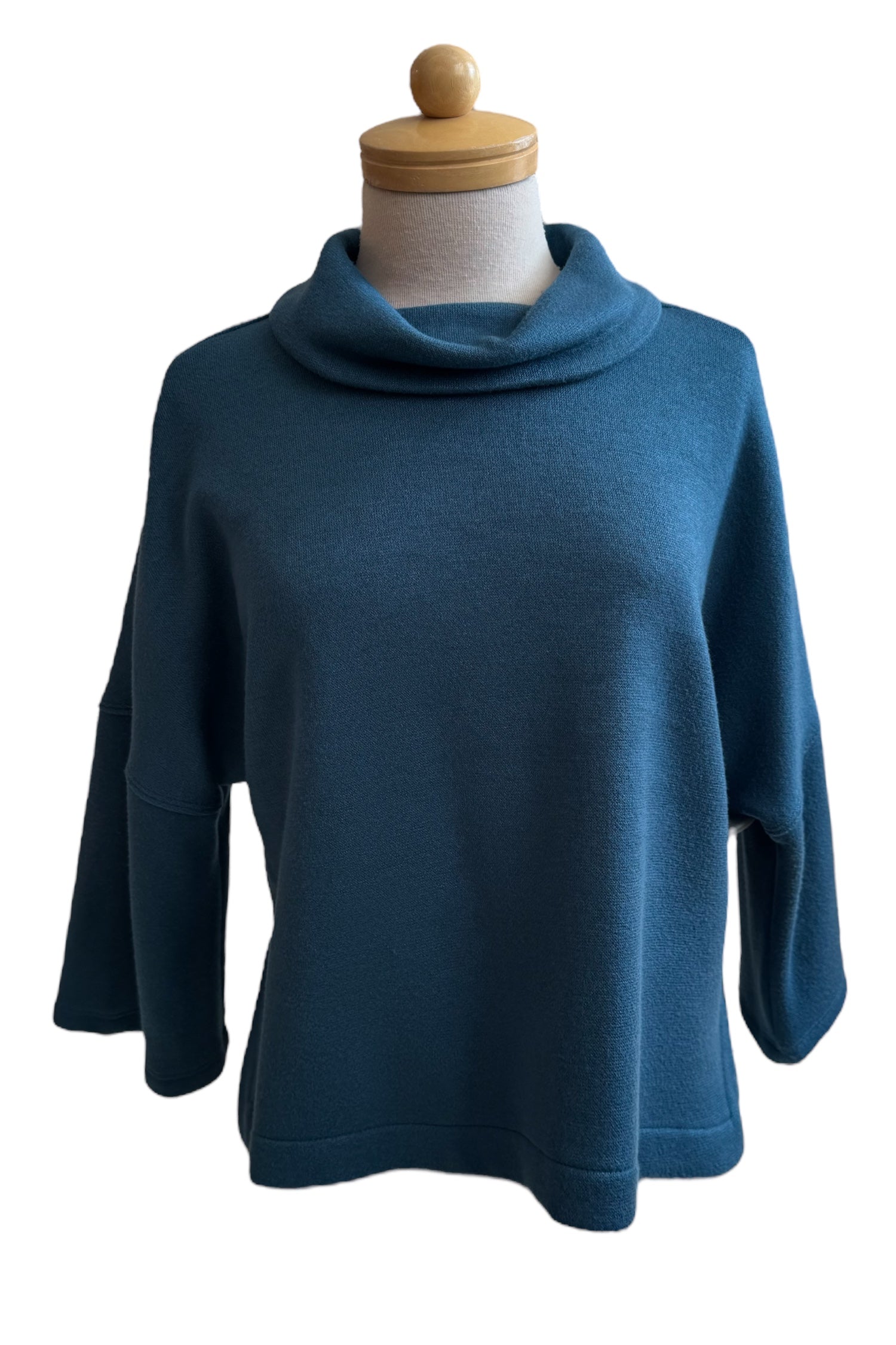 The Paige Sweater by Compli K in Peacock, featuring a large cowl neck, drop-sleeves, a loose fit, and side slits, is shown on a mannequin against a white background. 