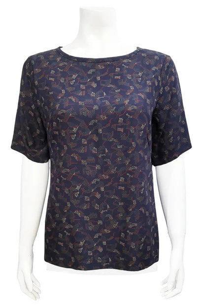 The Cecil Box Blouse by Mandala in Night Hex print is shown on a mannequin against a white background. It has a high neckline, wide 1/2 sleeves, and a side hem slit detail. 