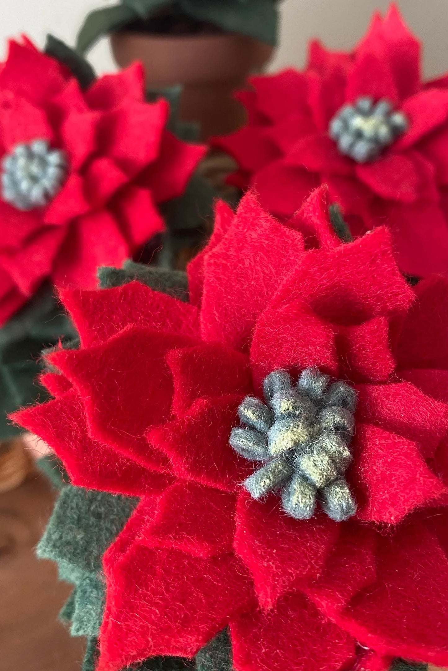 A close up of the Holiday Felt Poinsettia by ForgetBKnot.