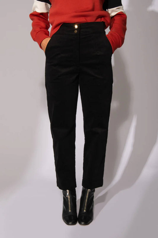 Waist down view of a woman wearing the Comin' Through Corduroy Pants by Eve Lavoie in Black, with the Sour Time crewneck in Terracotta