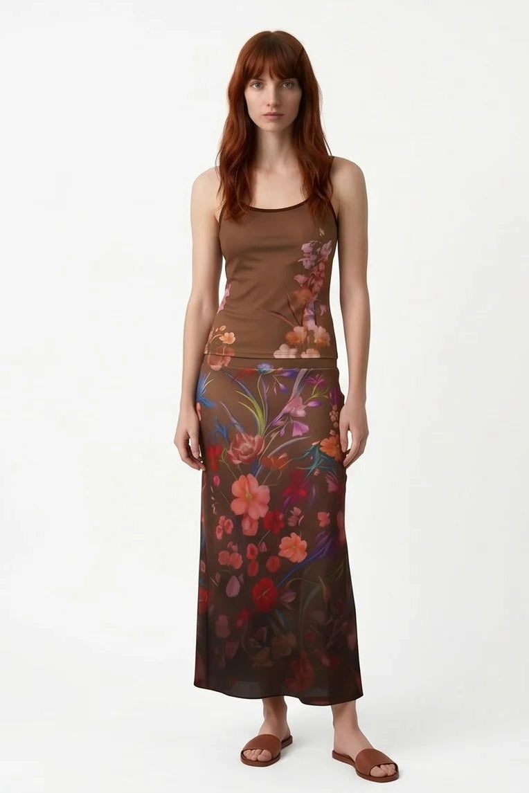A woman wearing the Morganne Top by Kollontai, a brown floral tank top with spaghetti straps. She is wearing it the matching Charlotte Skirt against a white background