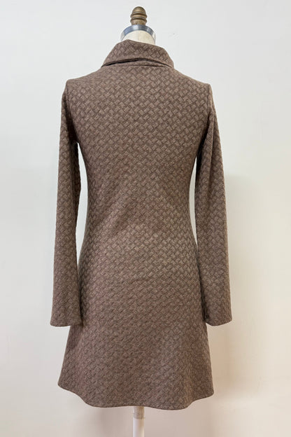 A back view of the Sacha Tunic by Kollontai in Brown, a textured knit straight cut tunic with a funnel collar and large patch pockets, is shown on a mannequin against a white background. 