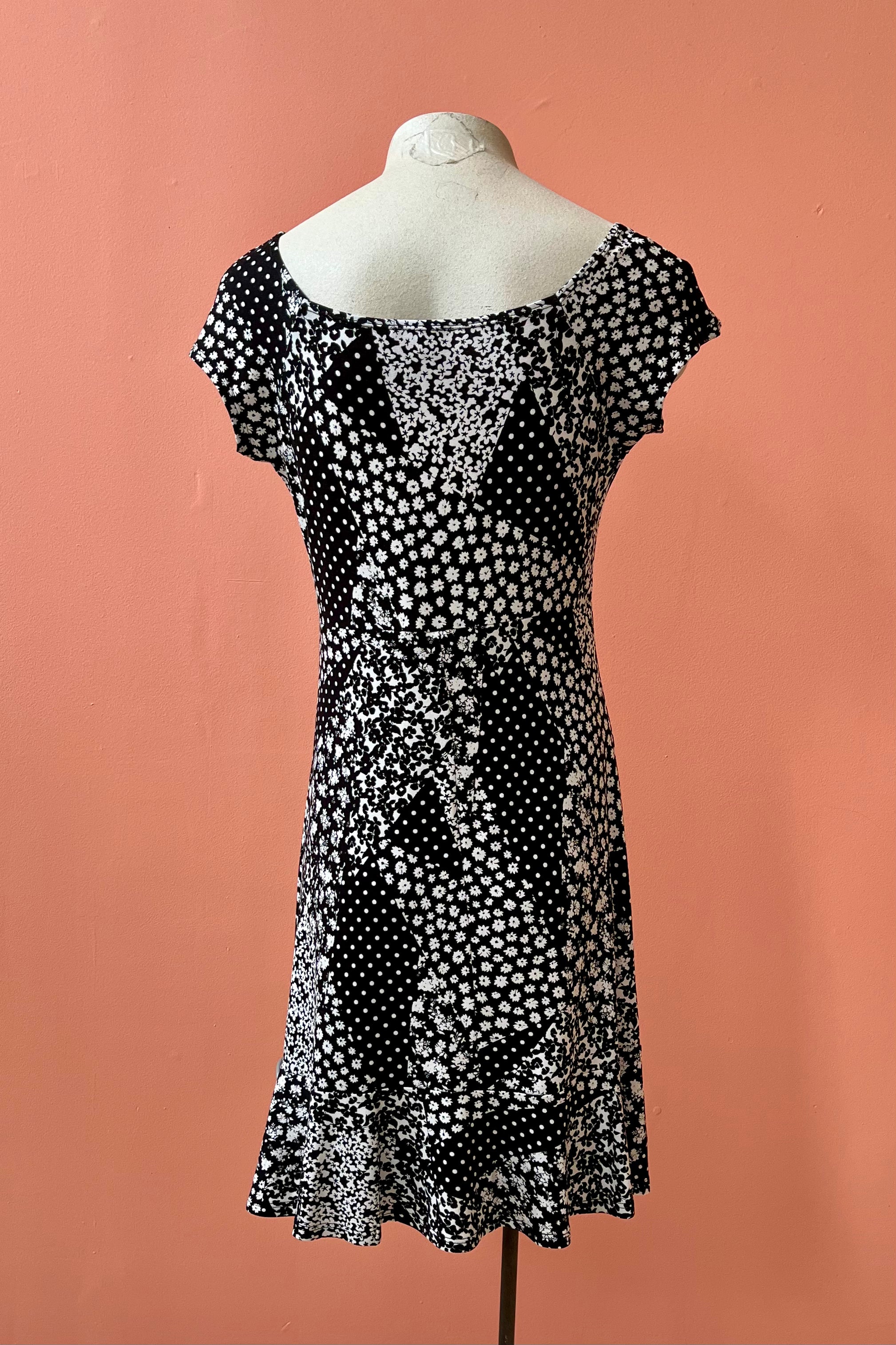 Lolita Dress by Luc Fontaine, back view, black and white floral patchwork print, sweetheart neckline, cap sleeves, fit and flare shape, ruffled hem, sizes sizes 4-16, made in Montreal