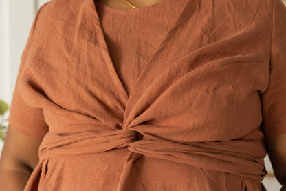 Close up bust view of a woman wearing the Stella Top by Lights of All in Sedona,, a short sleeved linen wrap top that can be twisted or tied back or front. She is wearing it over the matching Caroline dress.