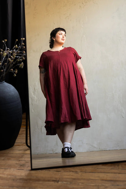 A woman wearing the Astoria Dress by Lights of All in Garnet