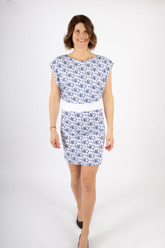 A woman wearing the Suki Dress by Infime in a Blue print standing in front of a white background 