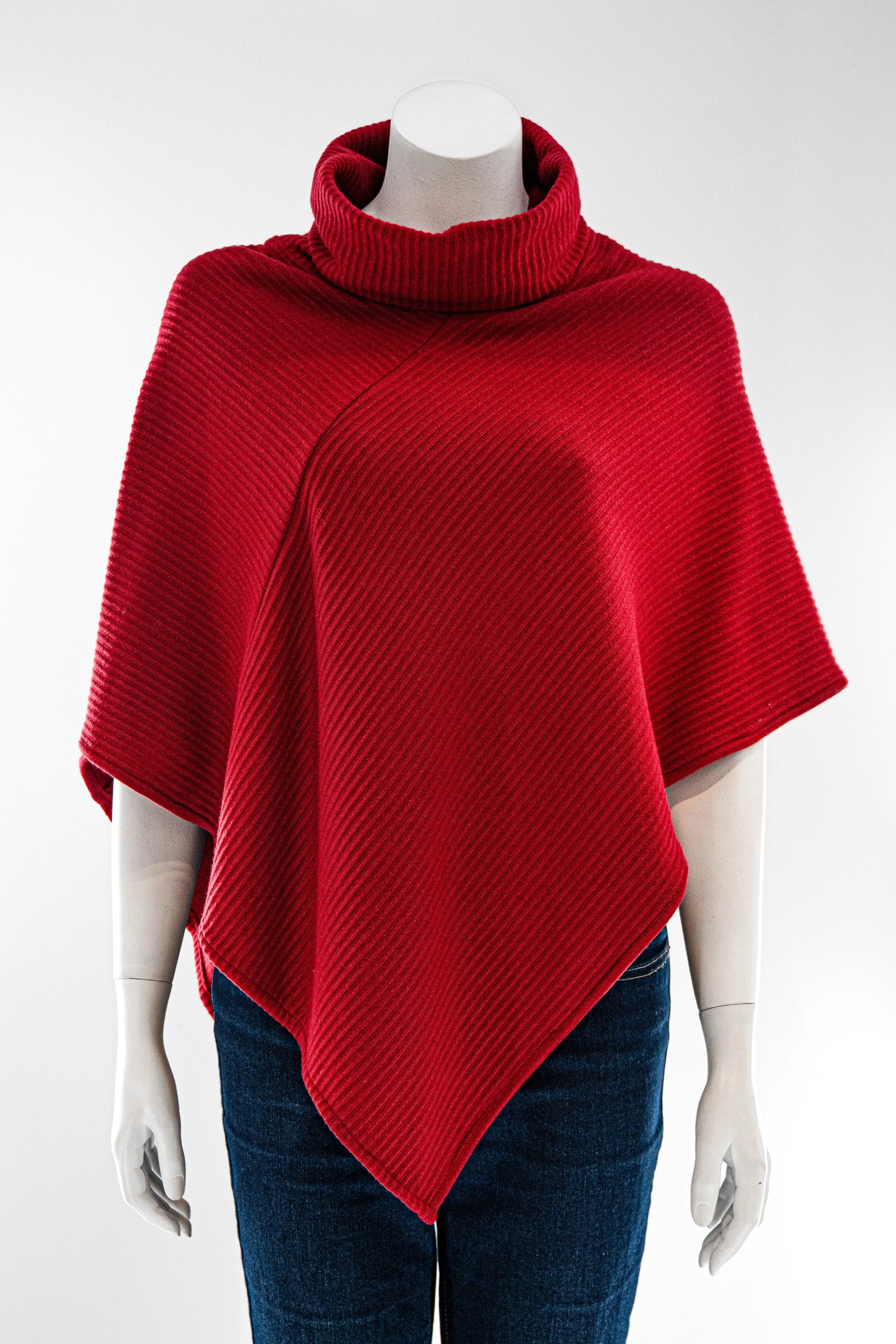 The winter Poncho by Karkass in Red, with a large turtleneck and angled hem, is shown on a mannequin against a white background