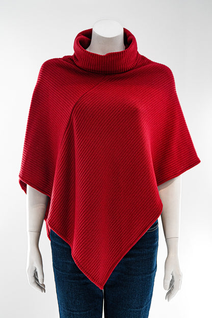 The winter Poncho by Karkass in Red, with a large turtleneck and angled hem, is shown on a mannequin against a white background