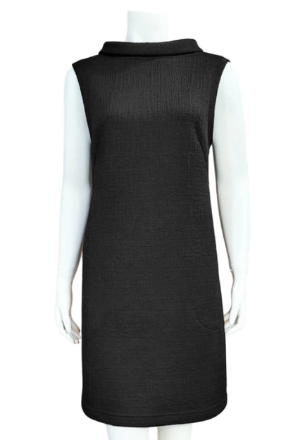 Mandala's Linus Jacquard Tunic in Black, a sleeveless piece featuring a roll collar, French darts, and pockets, is shown on a mannequin against a white background. 