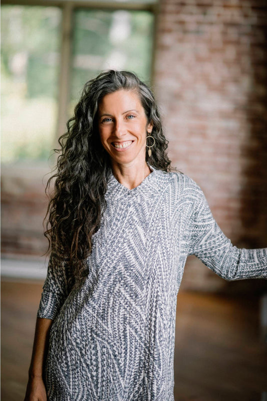 A woman wearing the Juliana Tunic by Marie C in Navy Print, standing in front of a brick wall 