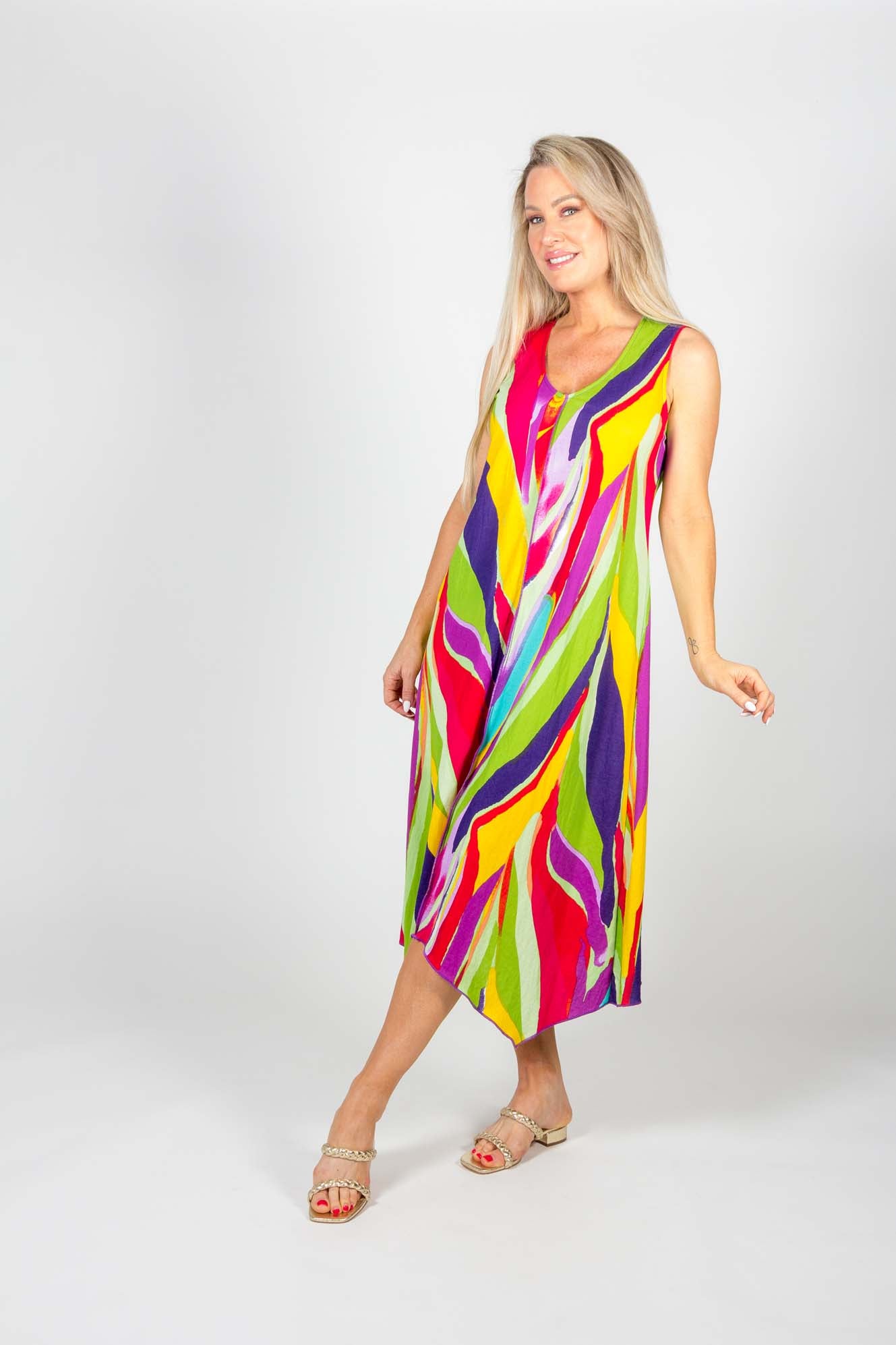 A woman wearing the Clara Dress by Pure Essence in Multicolour stands in front of a white background 