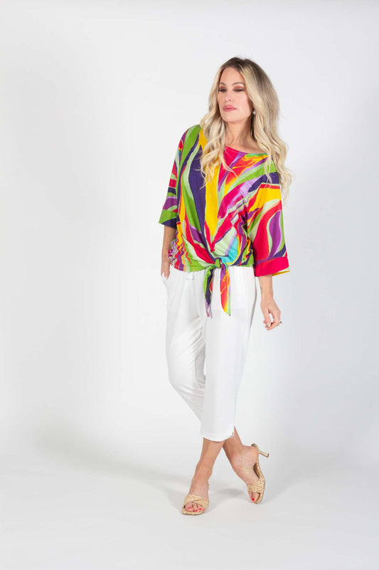 A woman wearing the Cybill Tunic in Multicolour by Pure Essence with white capri pants, standing in front of a white background 