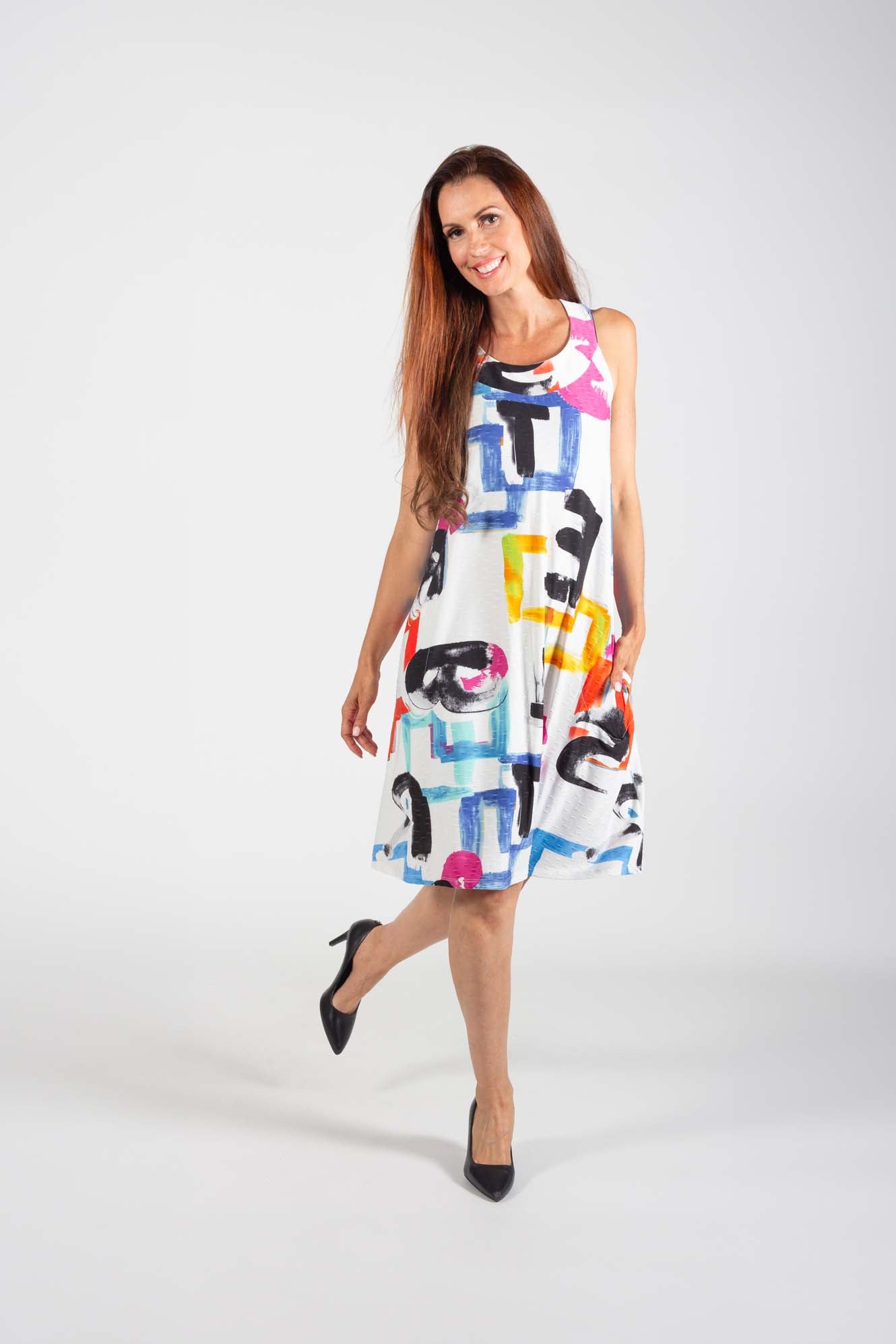 A woman wearing the Cymone Dress by Pure Essence in Multicolour print, standing in front of a white background