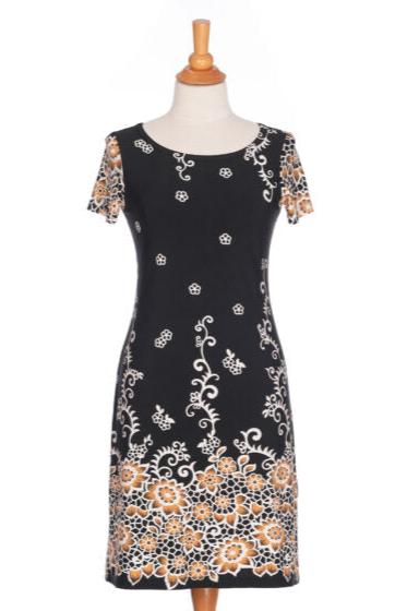 The Classic Dress by Rien ne se Perd in Black and Gold, a semi-fitted black  sheath dress with a gold floral pattern, short sleeves, and an above the knee length, is shown a mannequin in front of a white background. 