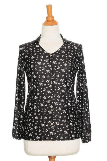 The Monet Blouse by Rien ne se Perd in Black and White Floral, with a V-neck, faux button placket with coconut buttons, loose fit, and long sleeves with gathered cuffs, is shown on a mannequin in front of a white background 