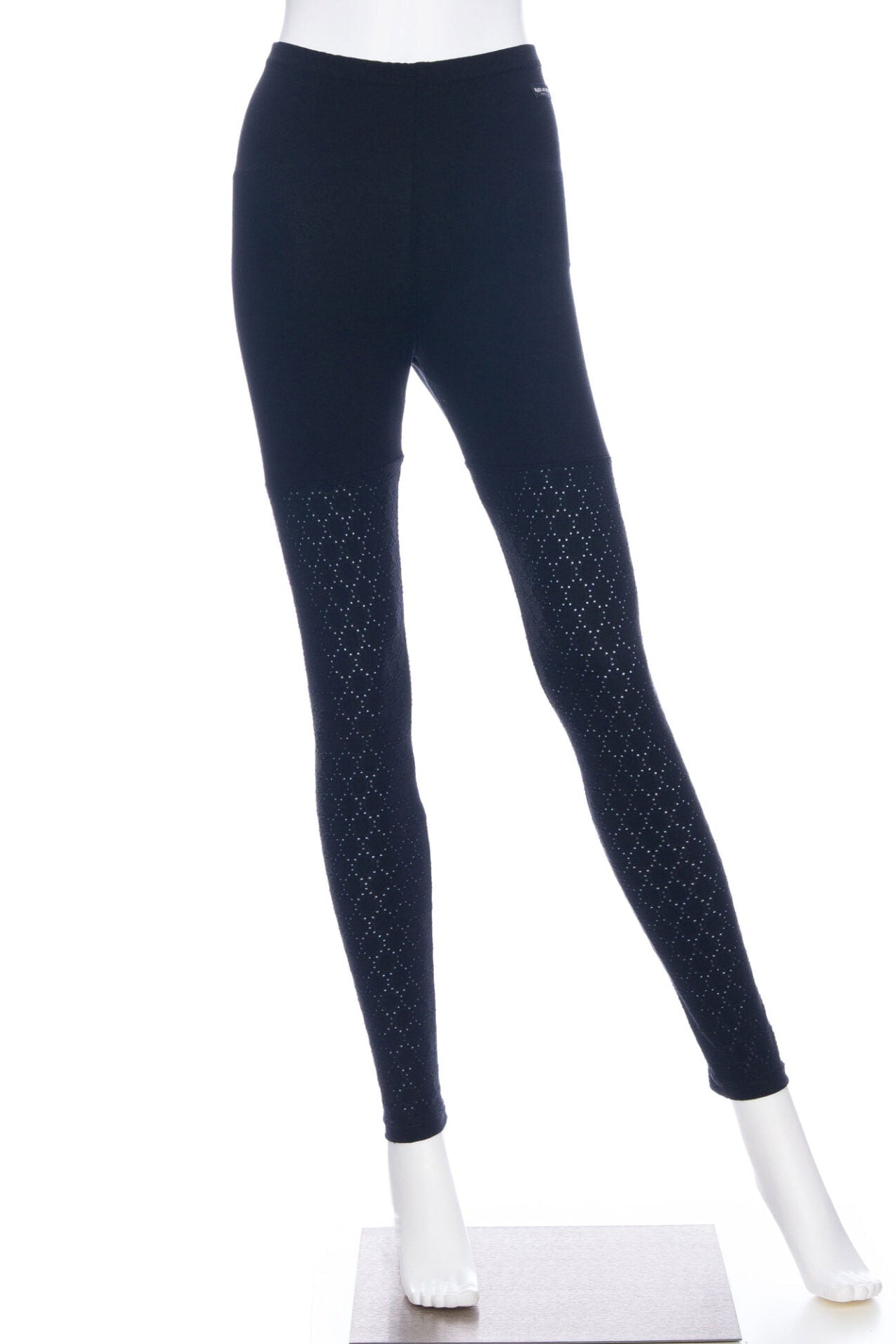 The Tsuga Leggings by Rien ne se Perd in Black, featuring textured fabric from the mid-thighs down and solid fabric from thigh to waist, are shown on a mannequin against a white background. 