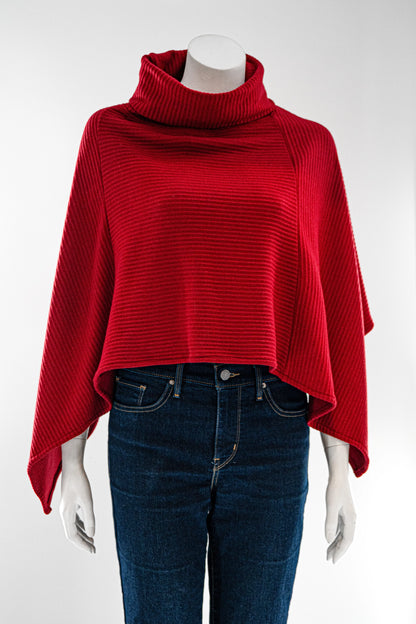 The winter Poncho by Karkass in Red, with a large turtleneck and angled hem, is shown on a mannequin against a white background