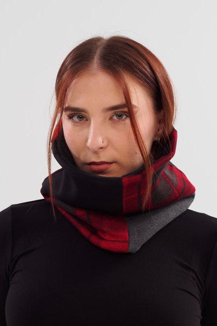 A woman wearing the Slak A24 Neck Warmer in Red, made of contrasting scraps of fabric from the current collection and lined with polar fleece.