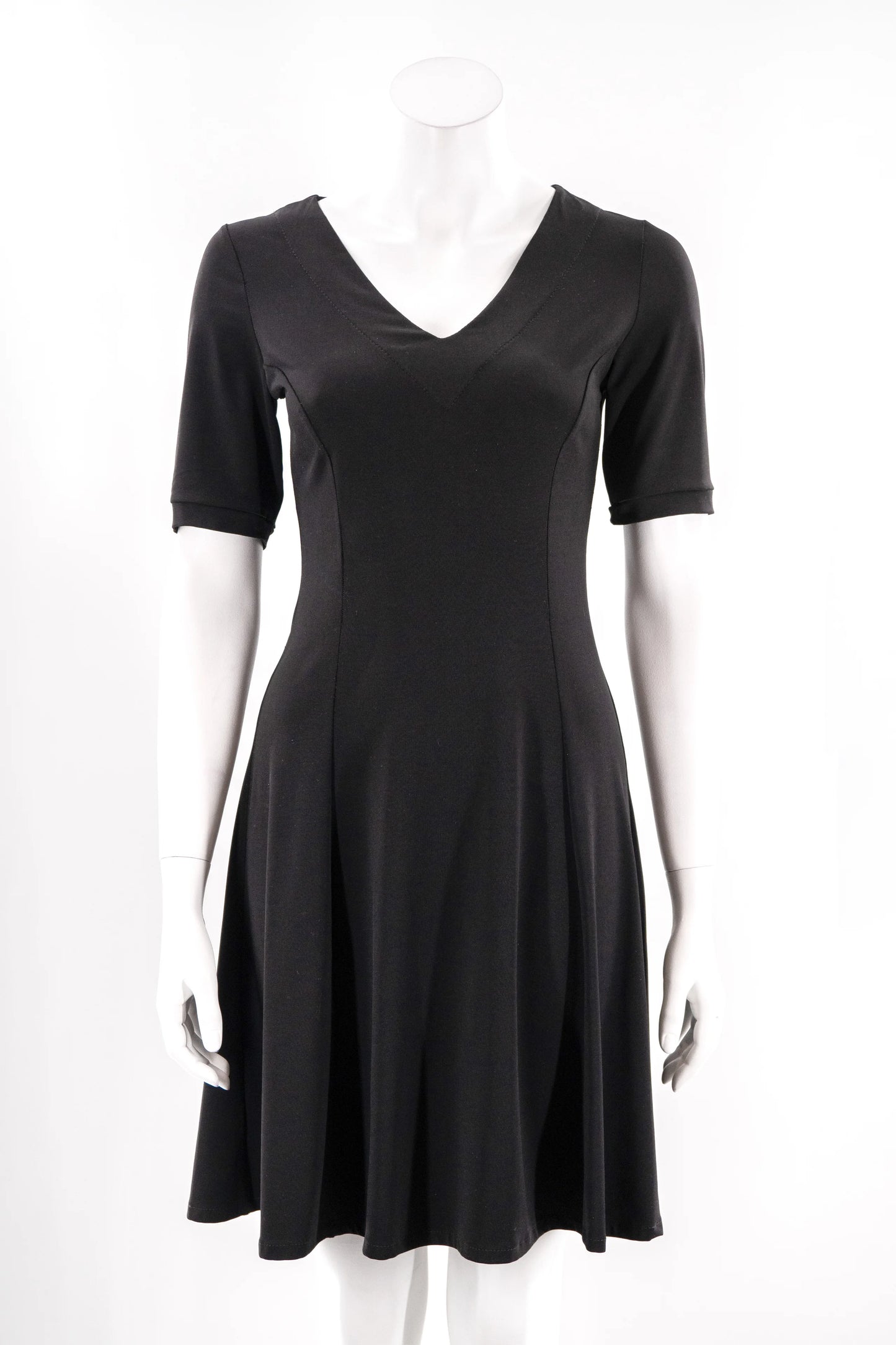 The FW Classic Dress by Karkass in Black, with short sleeves, a v-neck, and fit and flare shape that falls to the knee, is shown on a mannequin against a white background