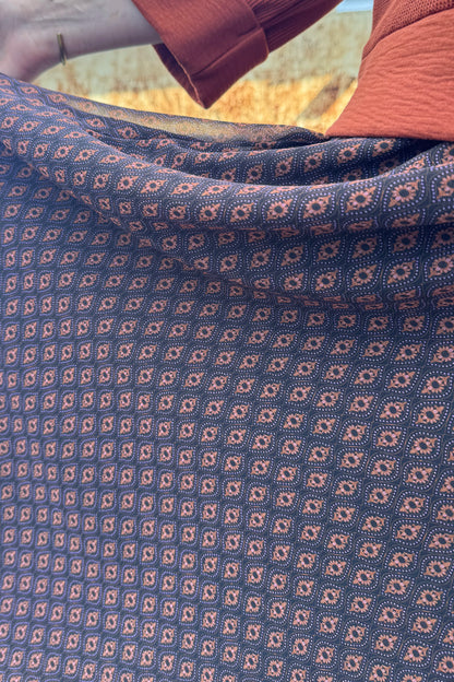 Close up showing the fabric detail of the A woman wearing the Espresso Skirt by Cherry Bobin in Black and Brown print.