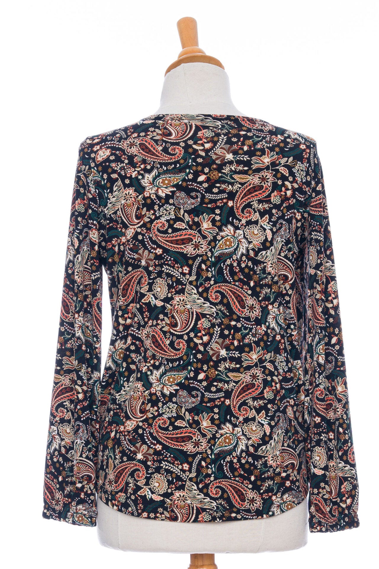 A back view of the Bruyère Sweater by Rien ne se Perd in Autumn Paisley print, with a round neck, relaxed fit, and long sleeves with cinched cuffs, is shown on a mannequin in front of a white background. 