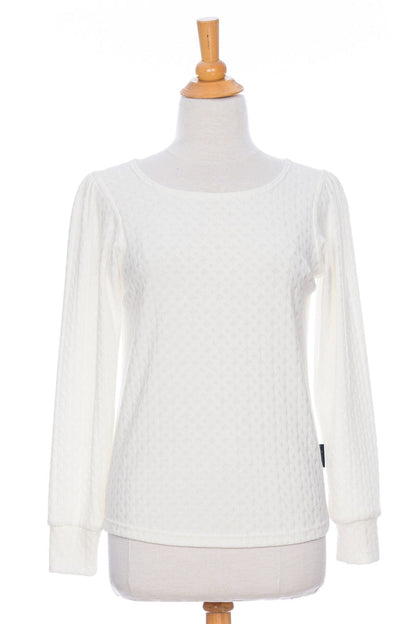 The Camarine Sweater by Rien ne se Perd in Ivory, a cable knit sweater with a scooped neck, puffed shoulders, and gathered cuffs, shown on a mannequin agains a white background. 