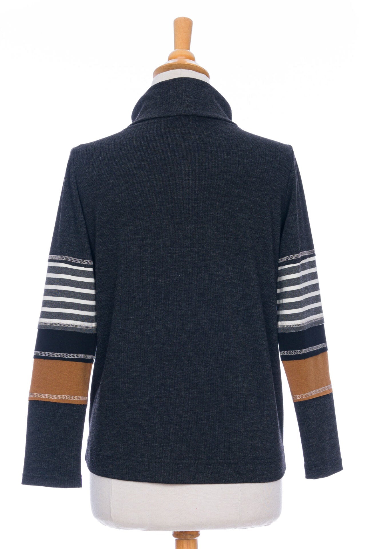 A back view of the Chicouté Sweater by Rien ne se Perd in Charcoal/Cognac, with a small turtleneck colour-blocked sleeves, is shown on a mannequin in front of a white background 