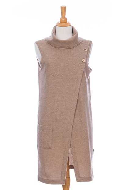 The long Baumier Vest by Rien ne se Perd in Natural, with a cowl neck, overlapping front, buttons and the shoulder and a patch pocket, is shown on a mannequin against a white background. 