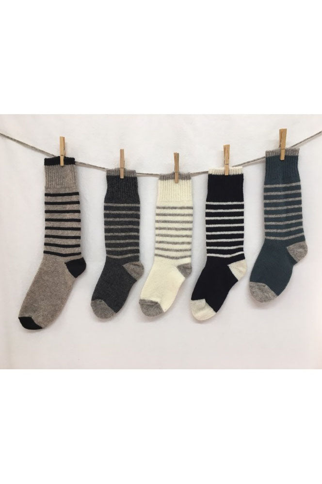 Knited Wool Socks by Charlevoix Pure Laine are shown hanging on a clothesline against a white background 