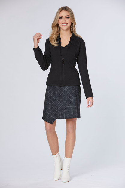 A woman wearing the Dilan Blazer by Luc Fontaine in Black with a plaid skirt, standing in front of a white background 