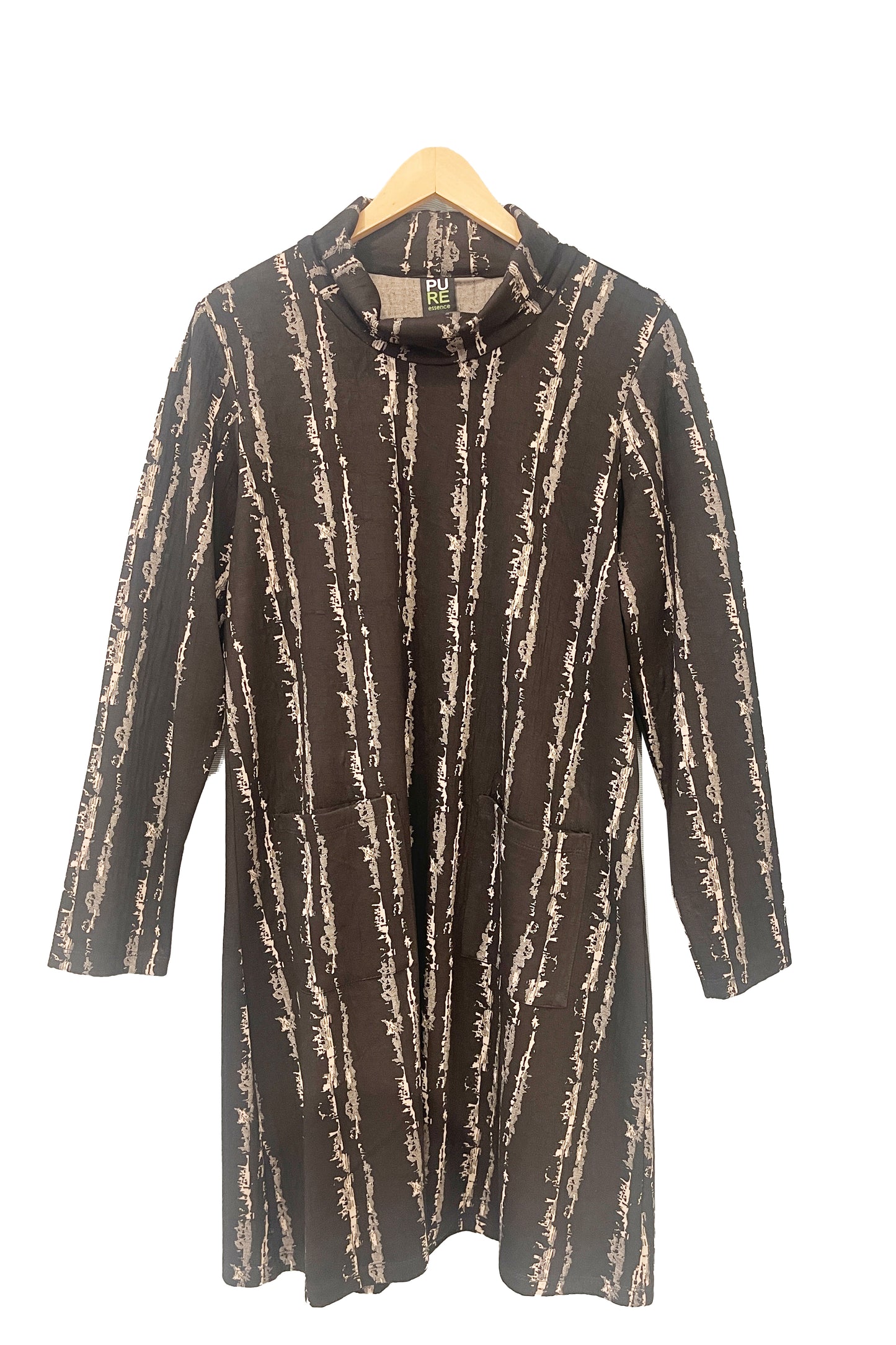 The Floella Dress by Pure Essence in Black/Tan, featuring a turtleneck, long sleeves, a slight a-line shape that hits the knee, and front patch pockets, is shown in front of a white wall. 