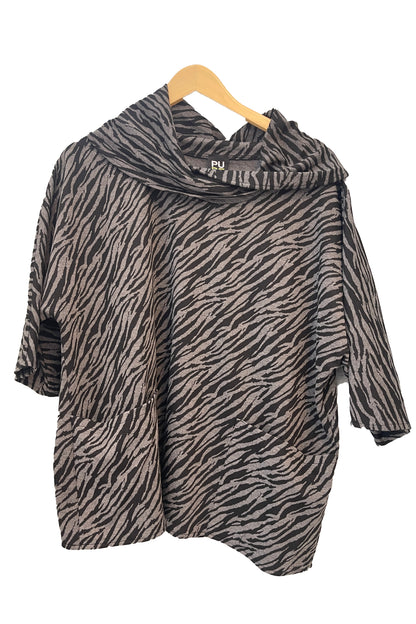 The Francis Tunic by Pure in Black/Charcoal animal print, featuring a turtleneck, 3/4 sleeves and two patch pockets, is shown hanging in front of a white wall. 