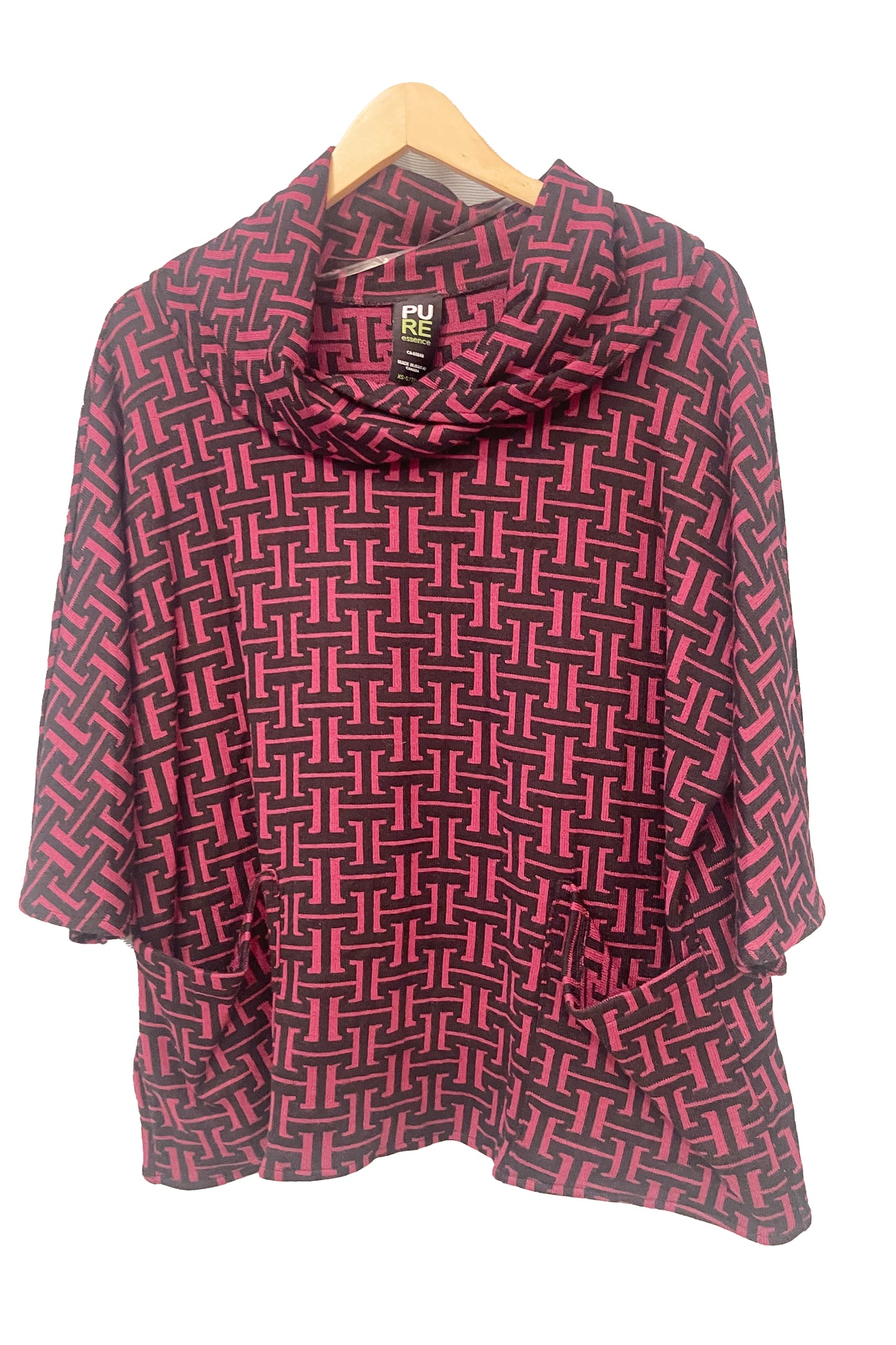 The Francis Tunic by Pure in Rosewood geometric print, featuring a turtleneck, 3/4 sleeves and two patch pockets, is shown hanging in front of a white wall. 