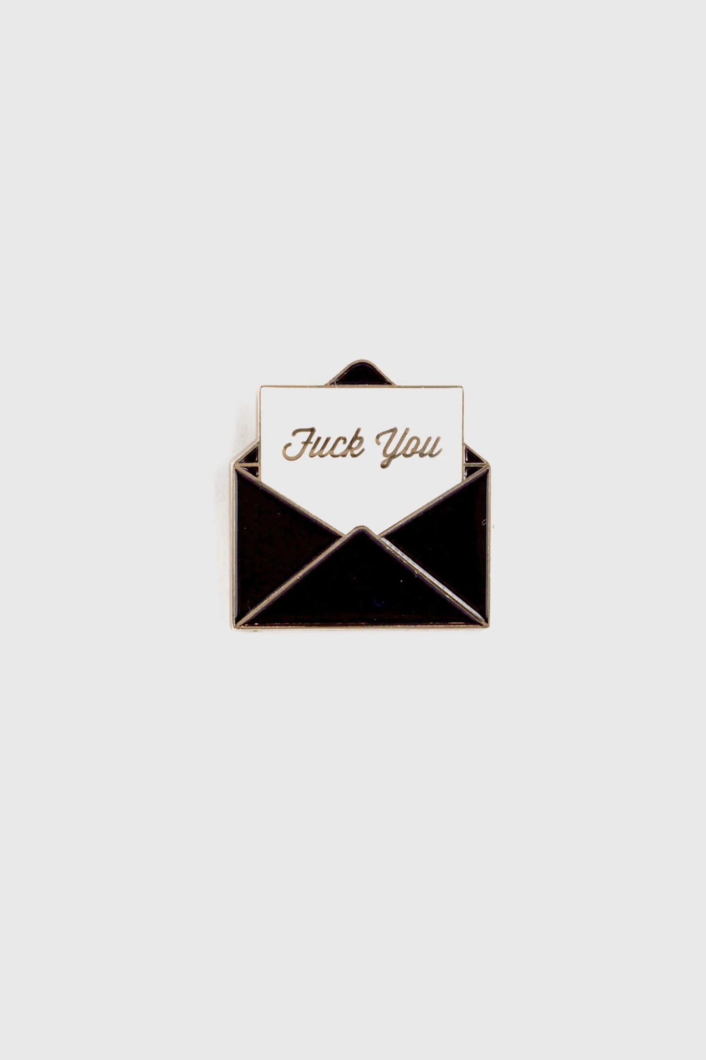 The Fuck You Pin by Badaboöm Studio, featuring a black envelope and white piece of paper that reads "fuck you" in gold lettering, is shown against a white background. 
