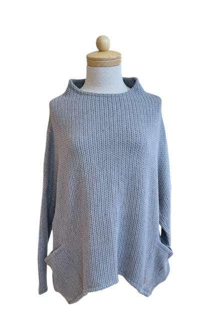 The Meeso Sweater by MOOVment in Grey, a One Size oversized knit sweater with a wide mock turtleneck, long dropped sleeves and large side pockets, is shown on a mannequin in front of white background. 